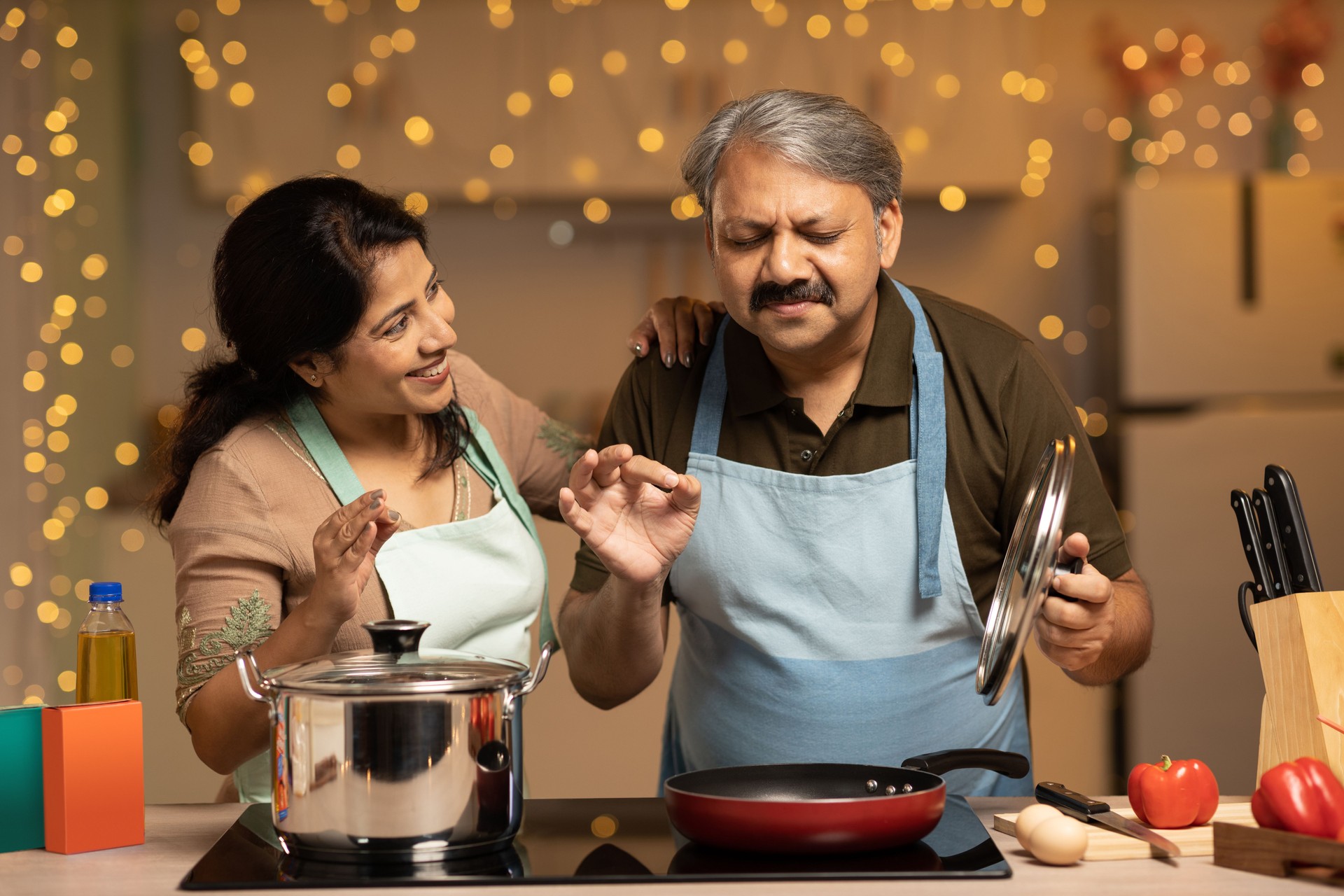 Smiling couple preparing food at home stock photo